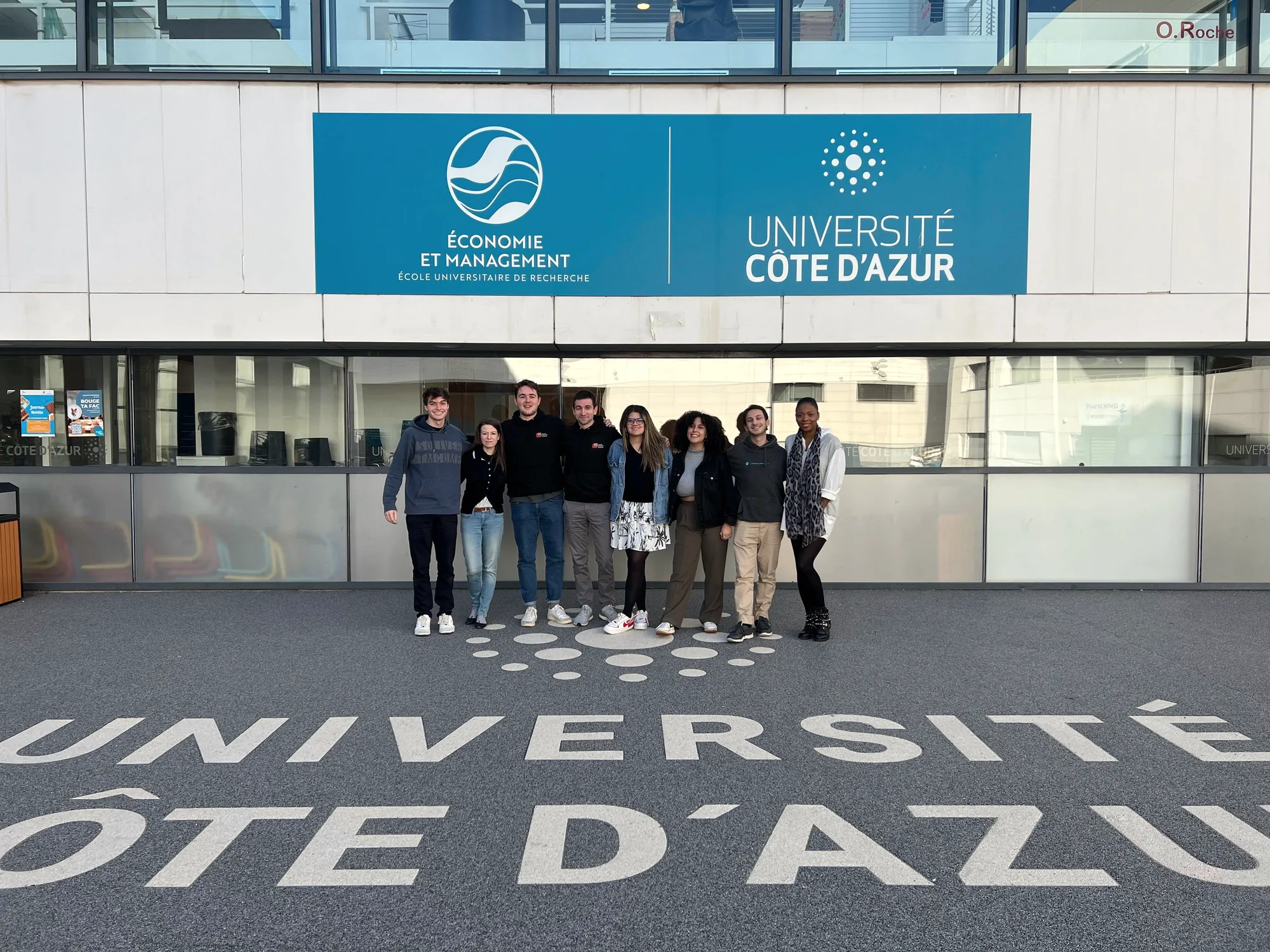 A student team stands in front of a Université Côte d'Azur building